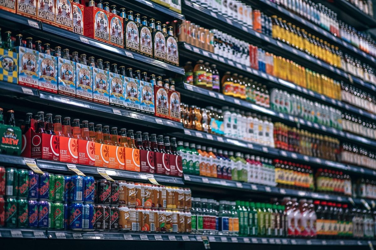 Rôzne farebné nápoje vystavené na regáloch supermarketu, široká ponuka osviežujúcich nápojov pre zákazníkov.