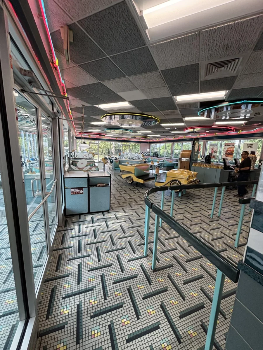 Interiér retro diner reštaurácie s farebnými neónovými svetlami a štýlovou výzdobou v americkom štýle.