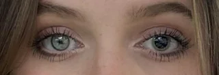 Oči s výraznými mihalnicami a svetlými modrými dúhovkami pod jemným make-upom.