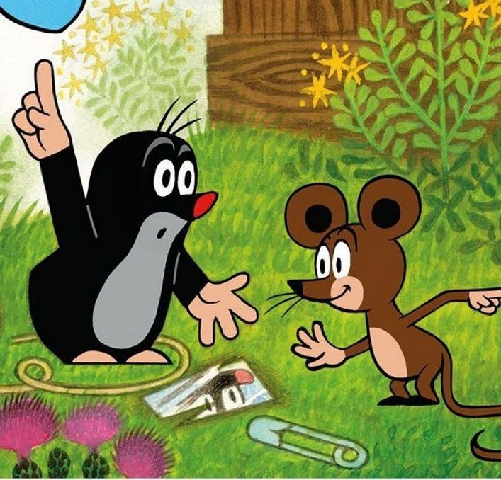 Krtko a myška diskutujú v záhrade medzi kvetmi a trávou, na zemi vidieť maketu domčeka a veľkú sponku.