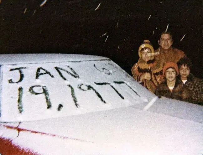 Rodina pózuje pri snežnej panoráme auta s nápisom dátumu 19. január 1977 na Aljaške.