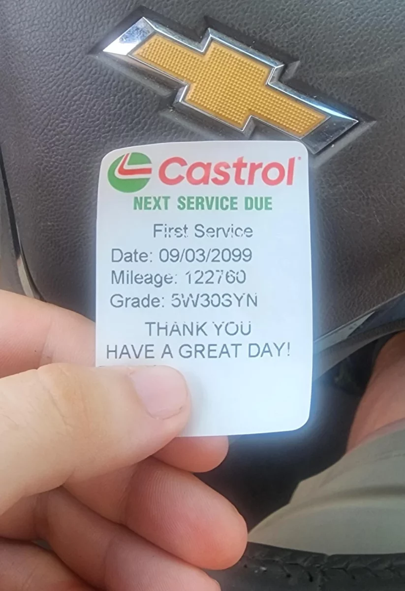 Nálepka Castrol na volante s dátumom ďalšieho servisu 09/03/2099 a počítadlom kilometrov 122760.