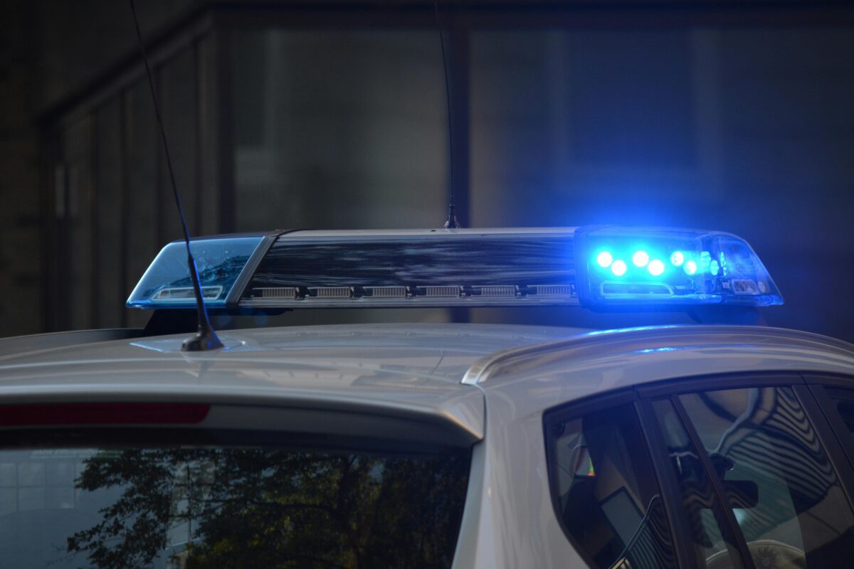 Policajné auto s modrými majákmi v akcii počas denného svetla.