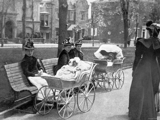 Historické kočíky na verejnom priestranstve, ženy s deťmi na lavičke v parku, koniec 19. storočia.