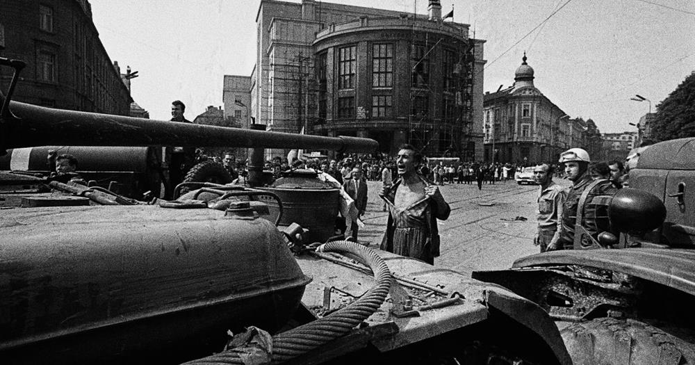 Človek protestuje pred tankami na ulici počas historického konfliktu v meste.