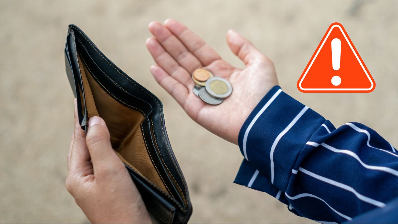 Prázdna peňaženka a niekoľko mincí v ruke s varovným symbolom – upozornenie na finančné ťažkosti.