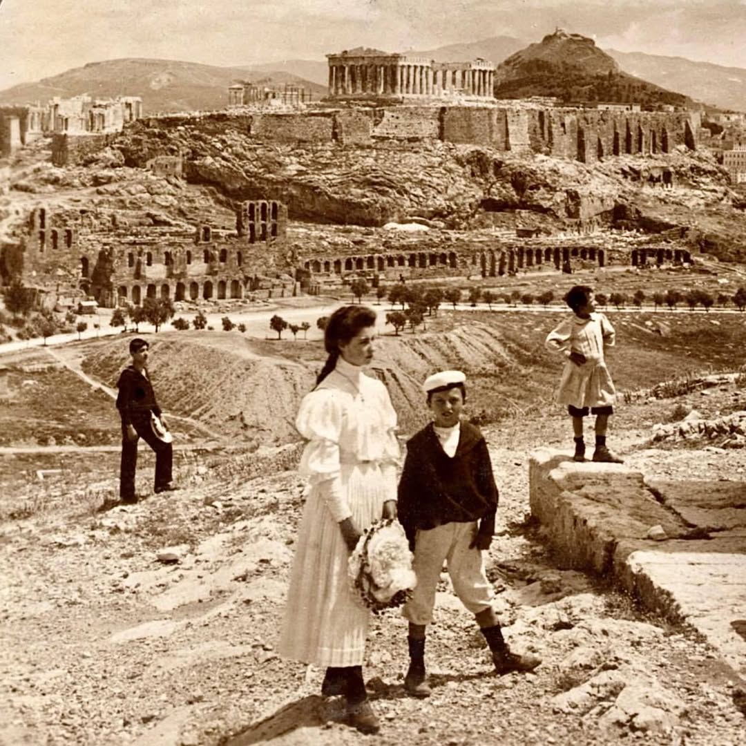 Staroveký Akropola v Aténach na historickej fotografii s ľuďmi na popredí.