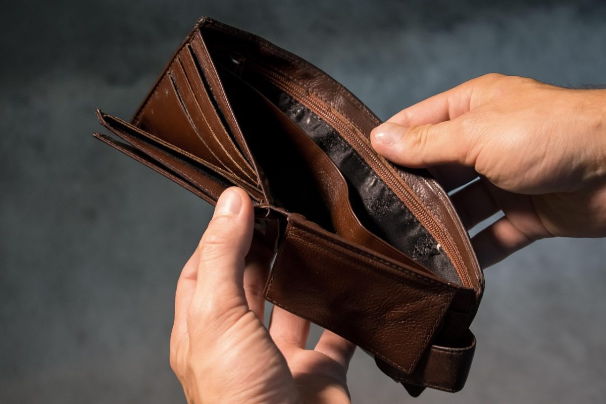 Prázdna peňaženka v rukách, symbol finančných ťažkostí alebo potreby šetrenia.