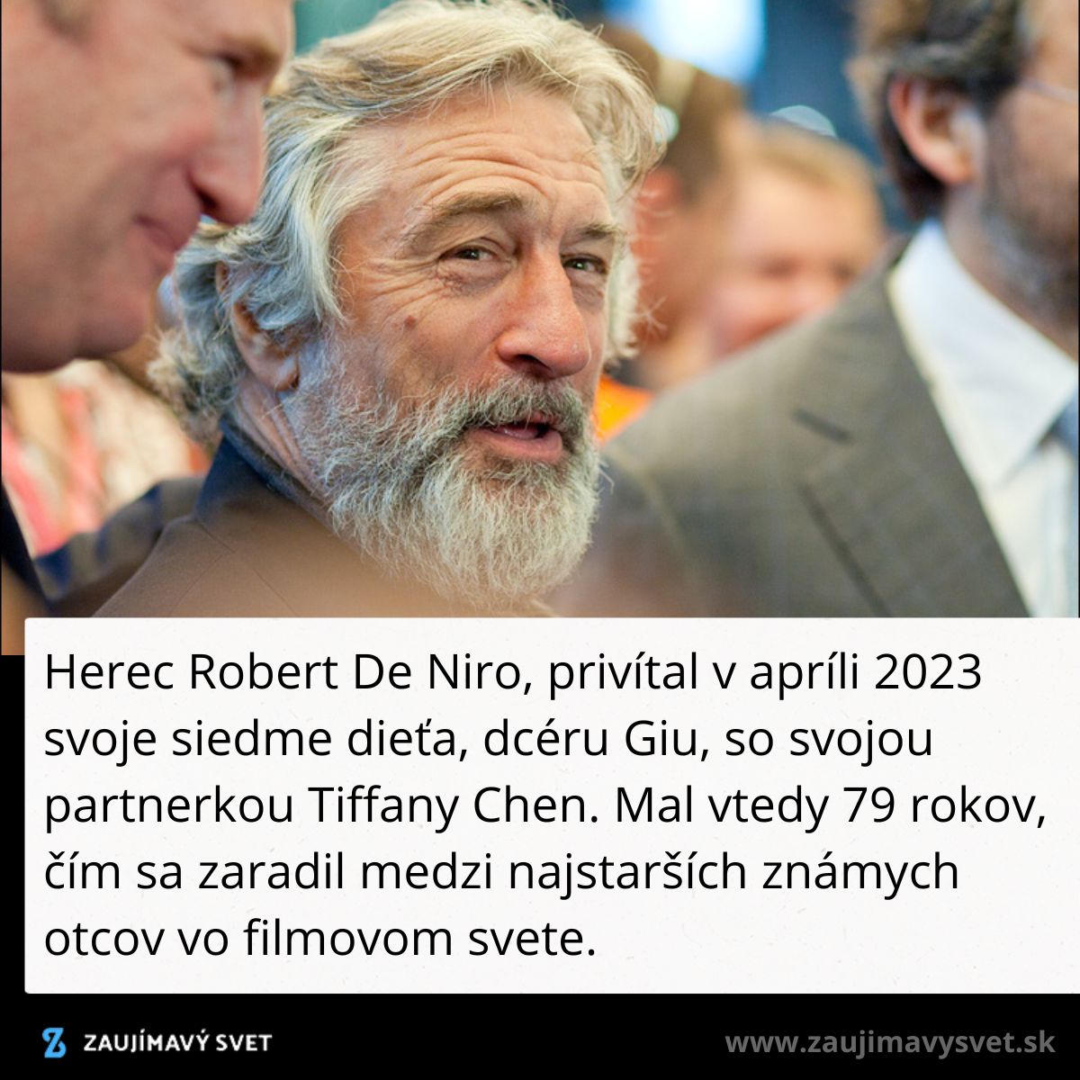 Muži v oblekoch diskutujú na udalosti; jeden starší s bradou, druhý v pozadí rozmazaný, okolo ruch publika.