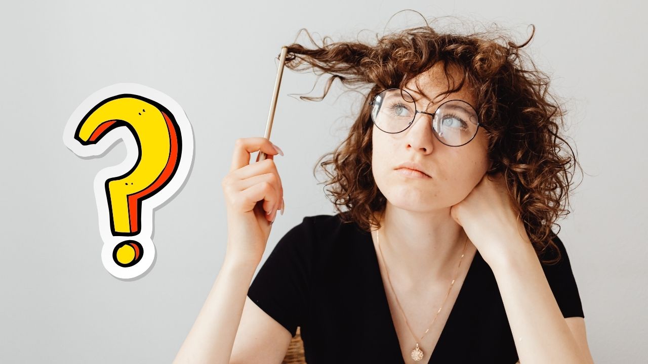 Žena premýšľa s ceruzkou vo vlasoch, vedľa nej veľký otáznik.