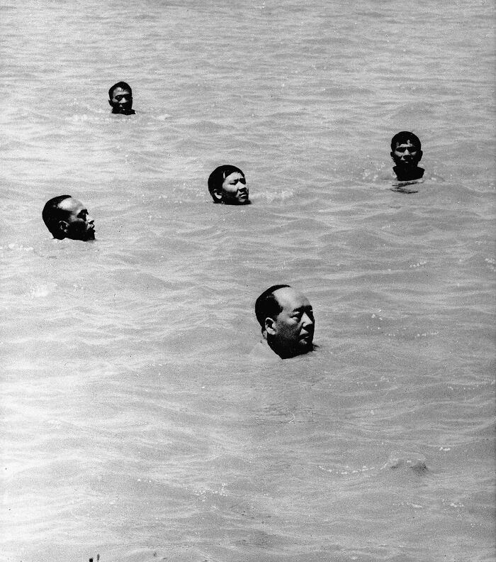 Muži plávajú vo vode za slnečného dňa. Historická čiernobiela fotografia.