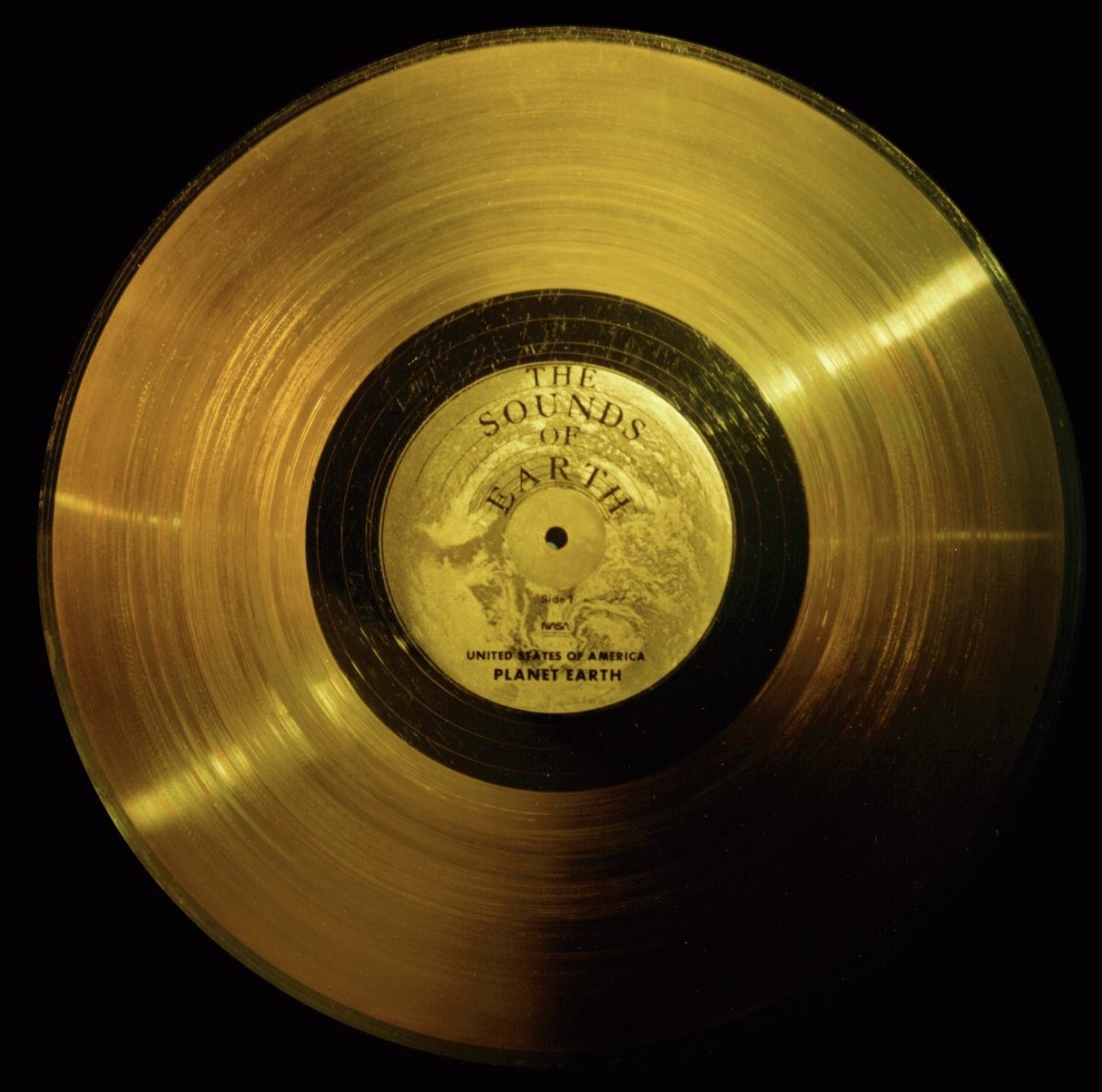 Zlatá platňa Voyager s nápisom The Sounds of Earth, symbol vesmírnej komunikácie.