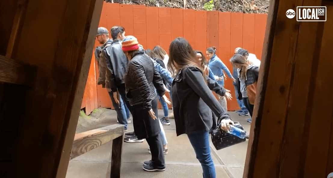 Ľudia sa nakláňajú v záhadnom dome s mimozmyslovou perspektívou, vytvárajúc ilúziu gravitácie.