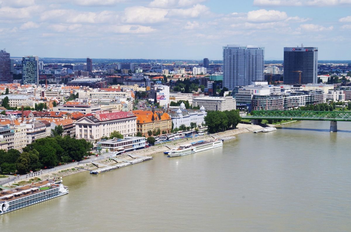 Pohľad na Bratislavu s Dunajom, lodným nábrežím a mestskou architektúrou počas slnečného dňa.