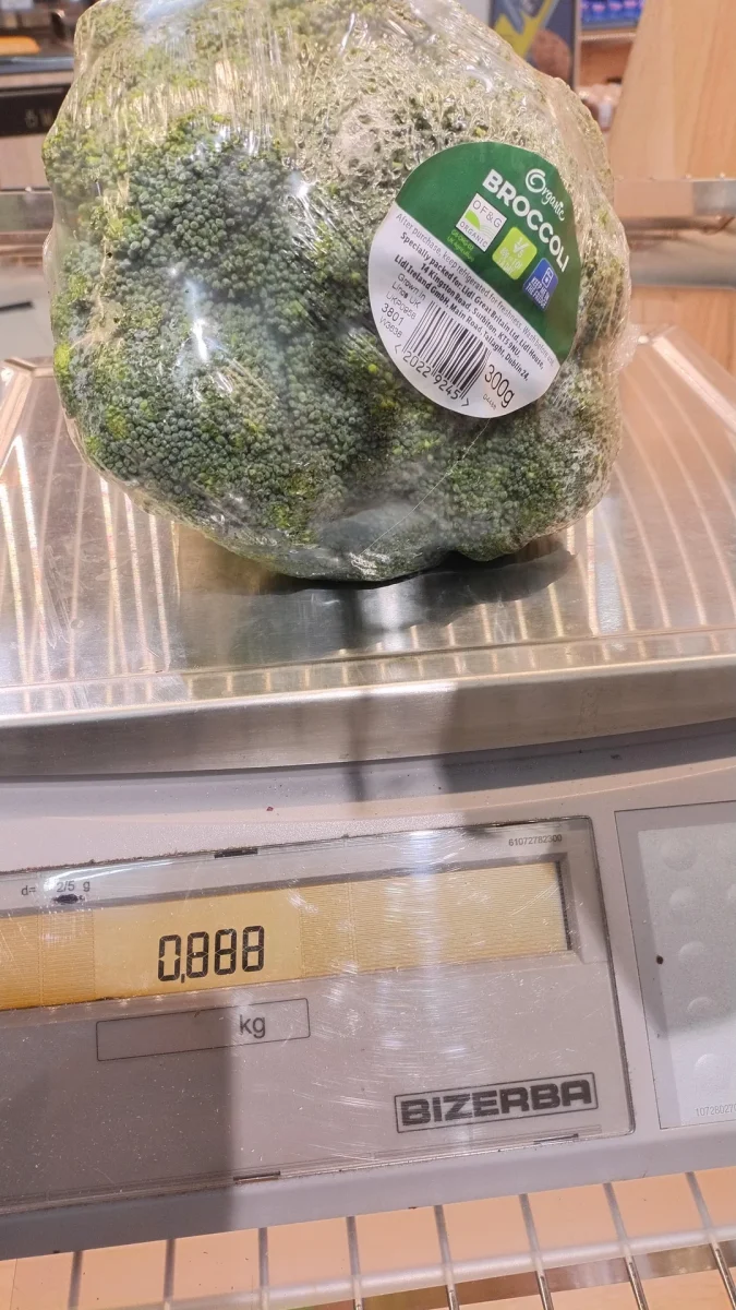 Čerstvá bio brokolica zabalená v plastovom obale na váhe, ukazujúcej hmotnosť 0,888 kg.
