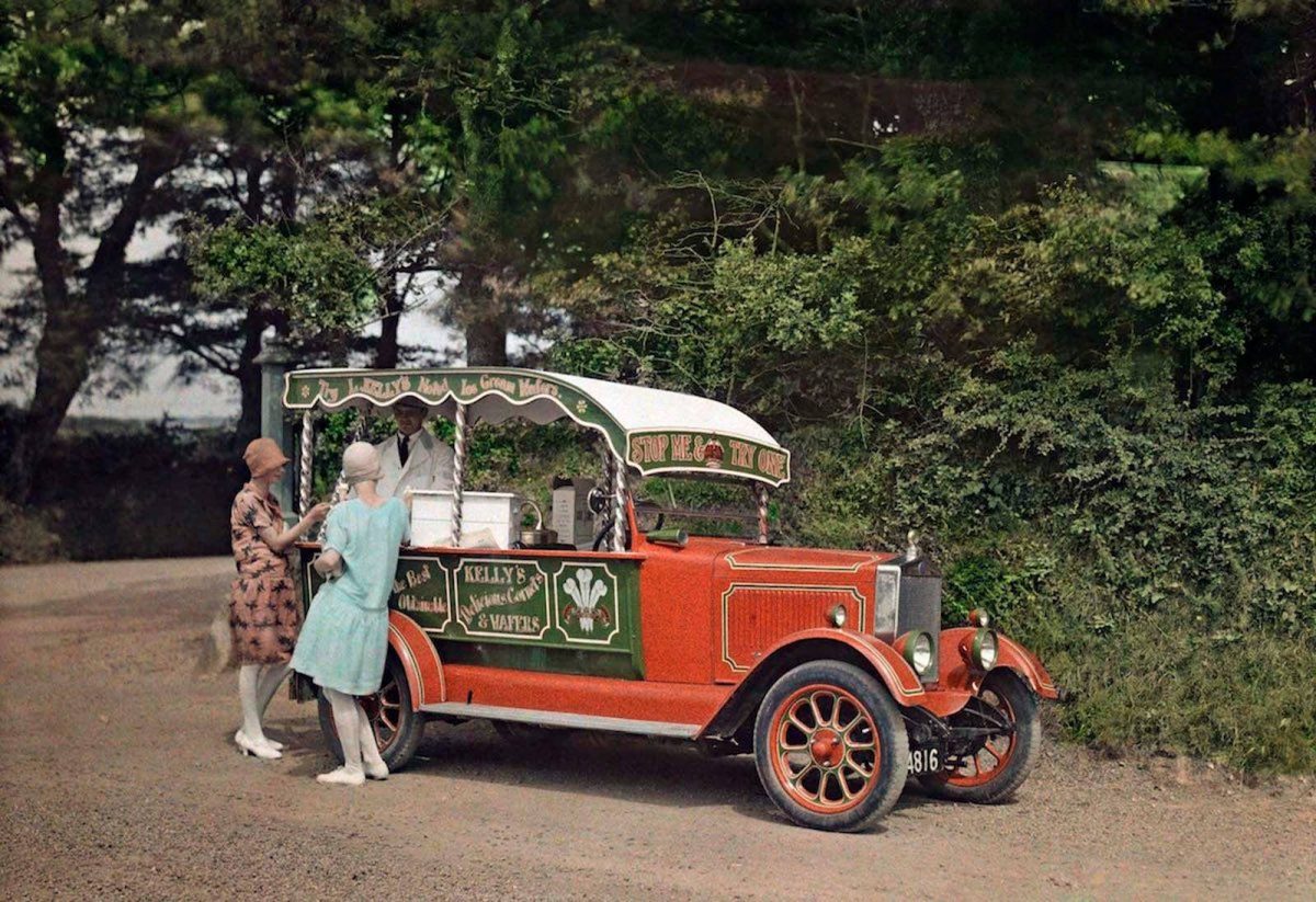 Historické auto s predajom zmrzliny, dve ženy si kupujú pochúťku, lesné pozadie.