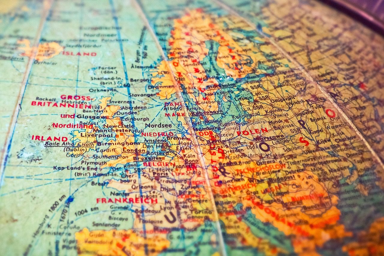 Mapa Európy ukazujúca krajiny ako Veľká Británia, Nemecko a Poľsko na otočnom glóbuse.