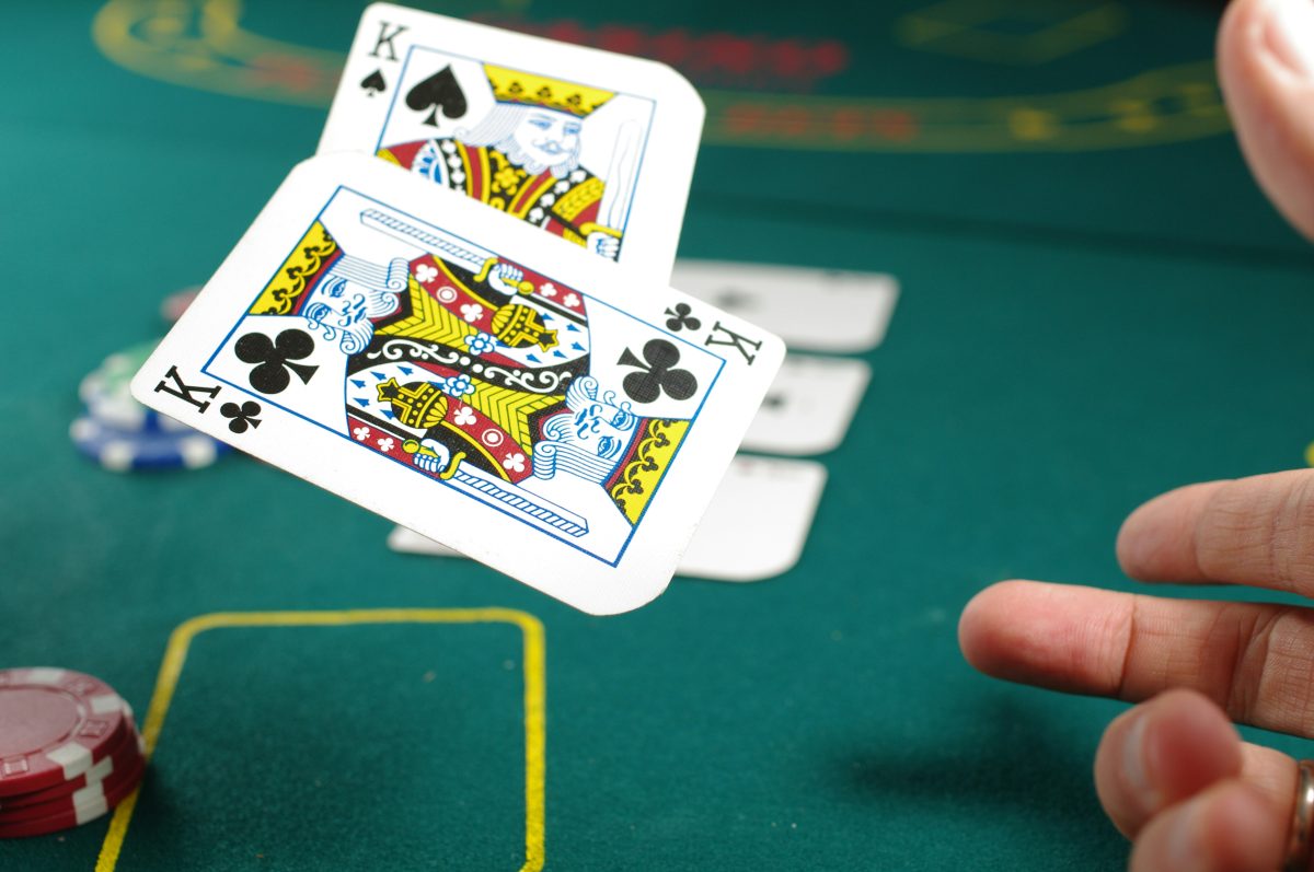 Pokerové karty a žetóny na stole, pokerová ruka kráľov.