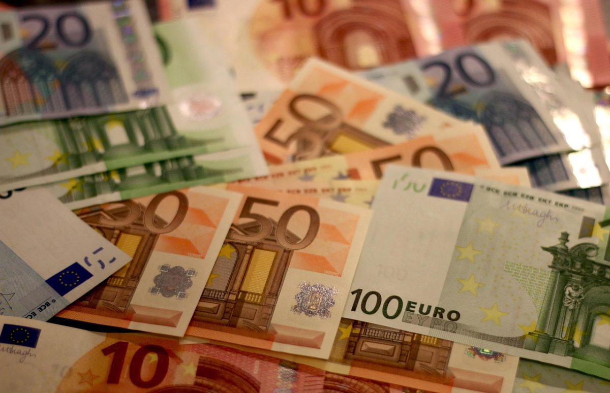 Euro bankovky rôznych hodnôt položené na sebe, symbolizujúce bohatstvo a financie.