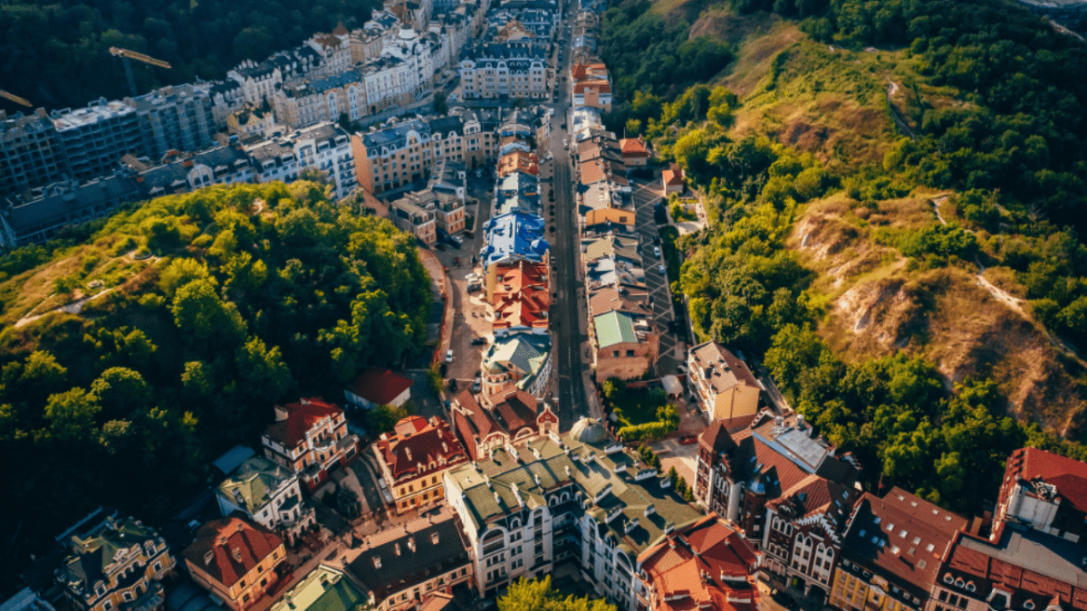 Letecký pohľad na malebnú ulicu obklopenú zeleňou a klasikou architektúrou v modernom meste.