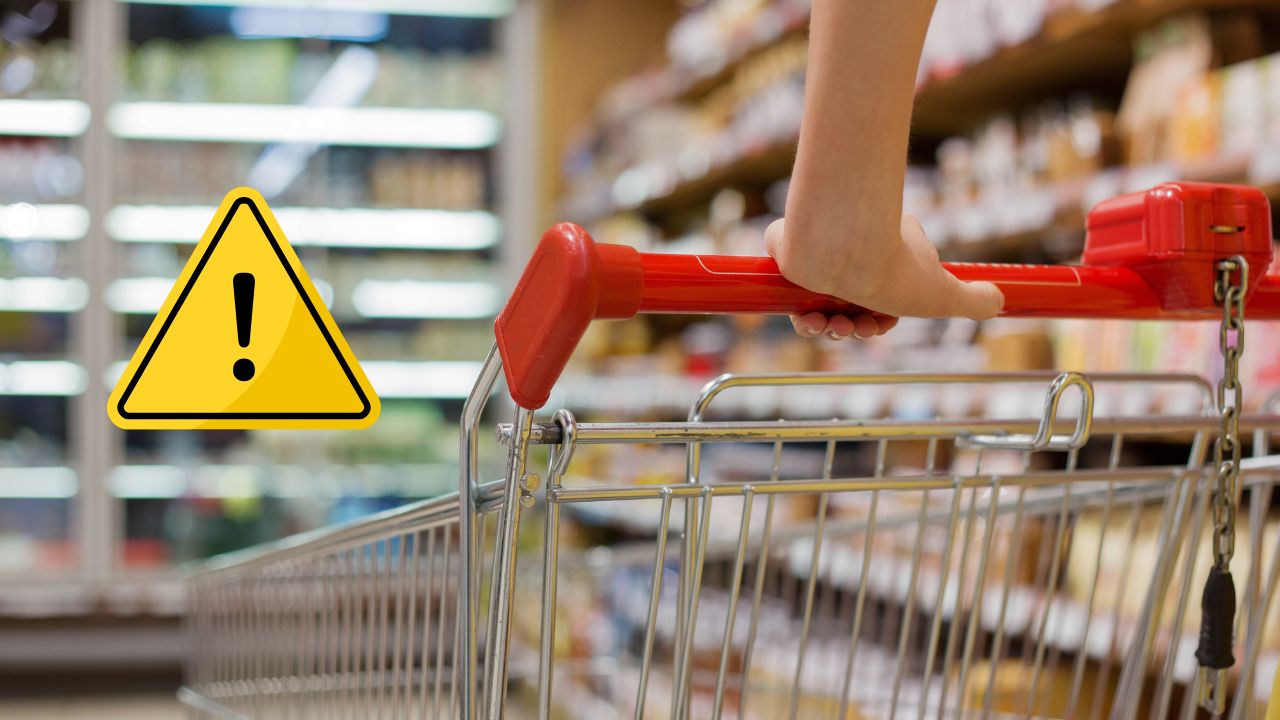 Ruka drží košík v supermarkete, vedľa je výstražná ikona s prázdnymi regálmi v pozadí.