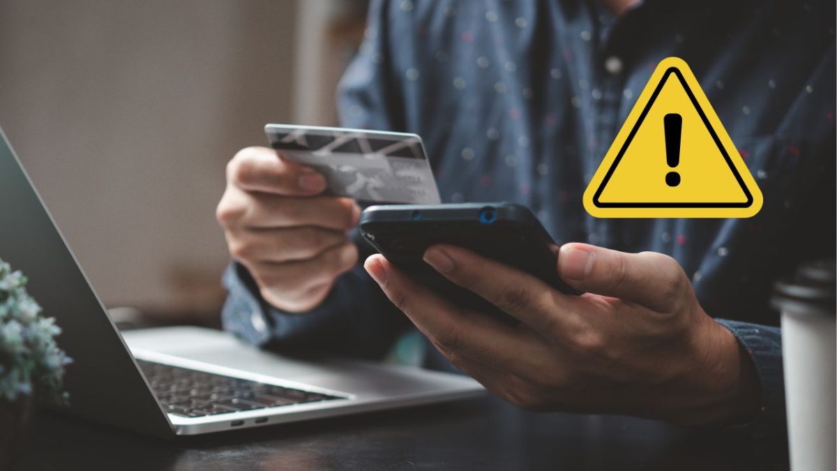 Osoba drží kreditnú kartu a mobilný telefón s varovaním o bezpečnosti online platieb.