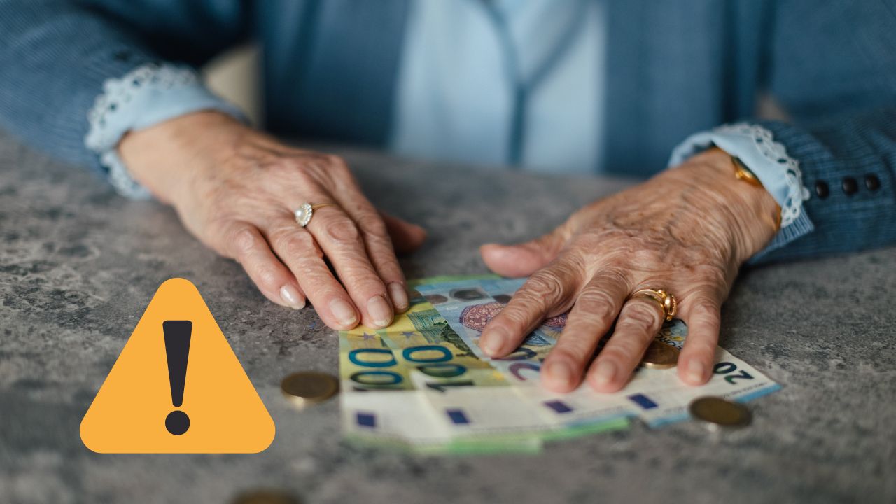 Staršie ruky s peniazmi na stole a varovným symbolom naznačujú riziko finančných podvodov voči seniorom.