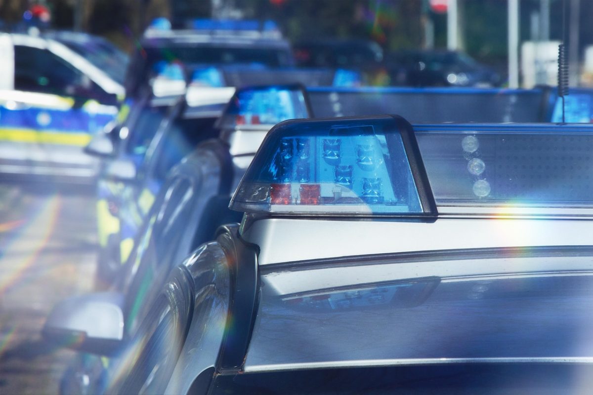 Policajné autá s modrými majákmi stoja v rade, pripravené na akciu.