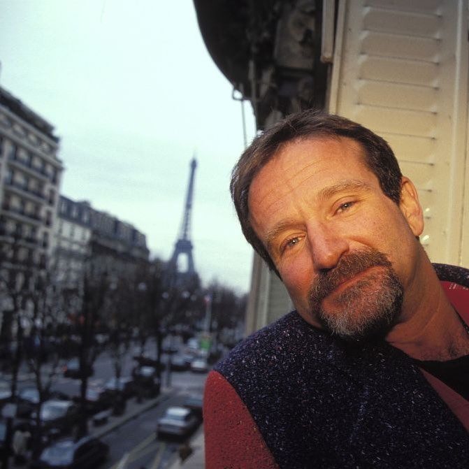Osoba na balkóne s výhľadom na Eiffelovu vežu v Paríži, v meste počas zamračeného dňa.