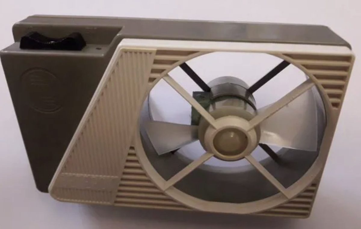 Stolný ventilátor v retro dizajne s plastovými lopatkami na bielom pozadí.