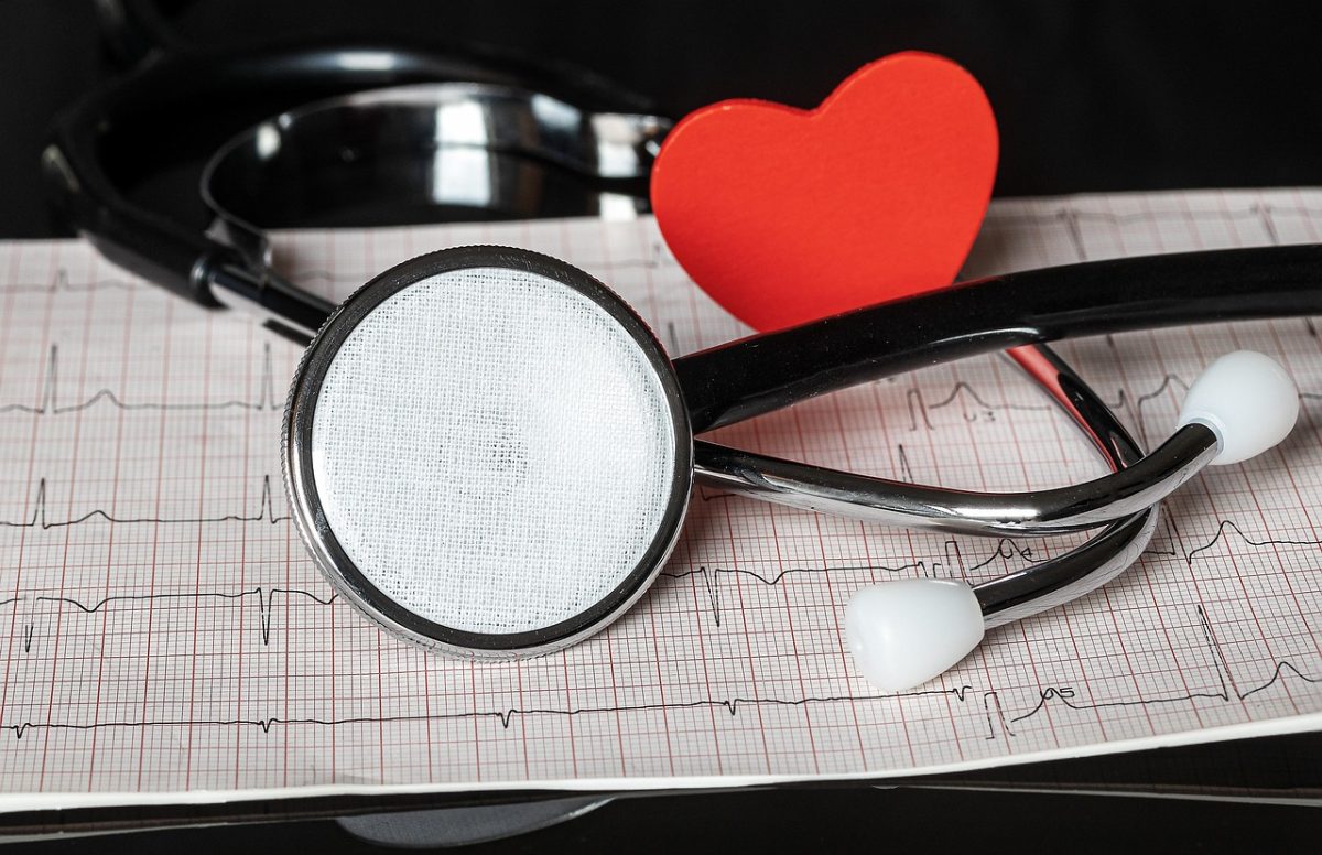 Stetoskop a červené srdce na EKG grafe symbolizujú starostlivosť o zdravie a kardiológiu.