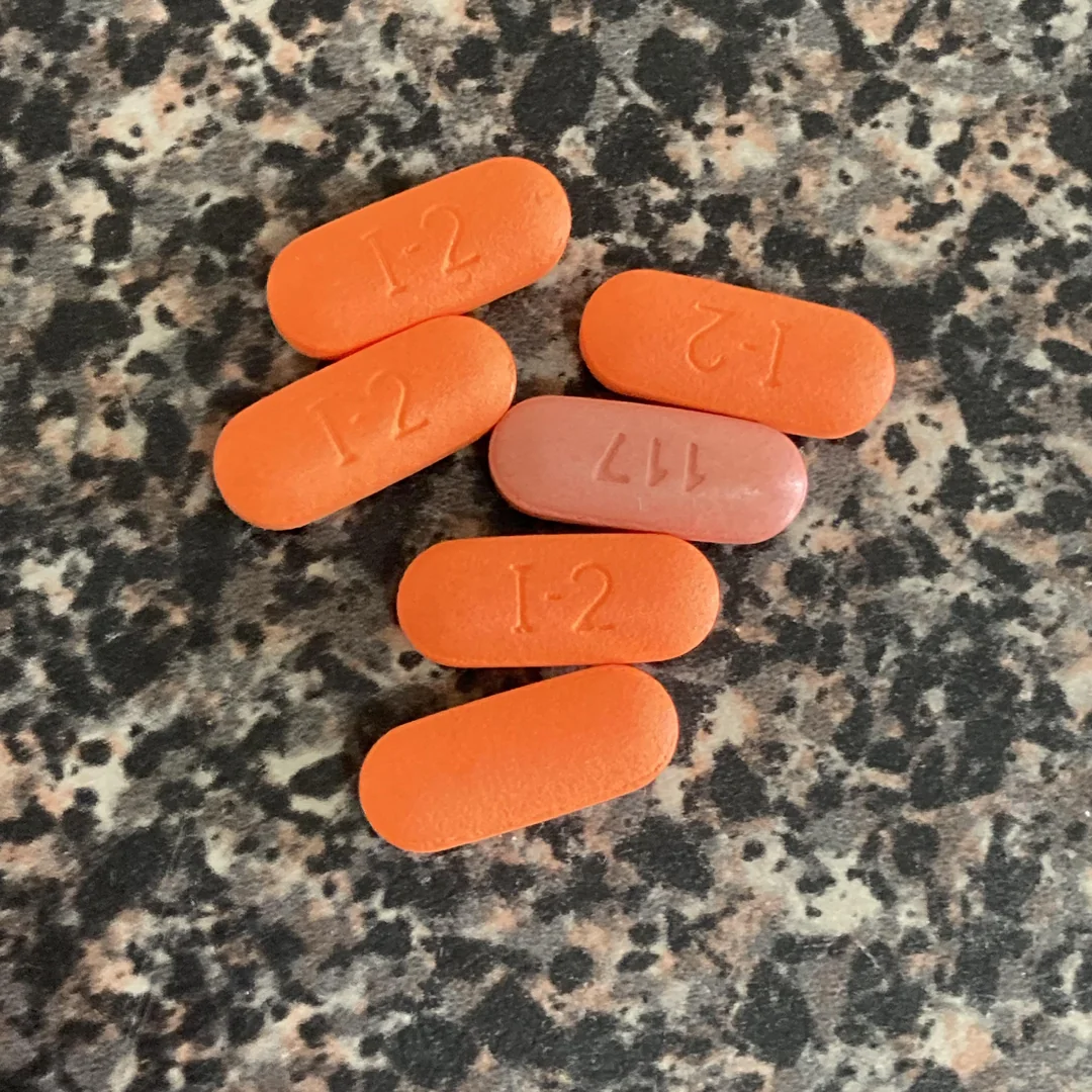 Orange pilulky I-2 a ružová pilulka 117 na mramorovom povrchu.