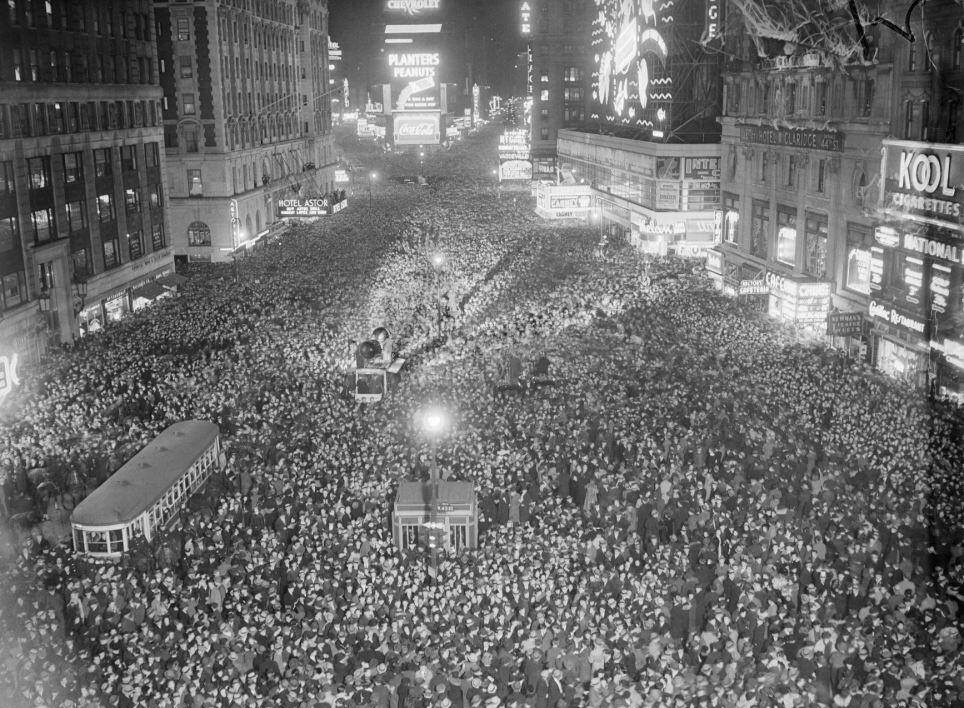 Dav ľudí na Times Square oslavuje Nový rok, ulice plné ľudí, svetelné reklamné tabule v pozadí.