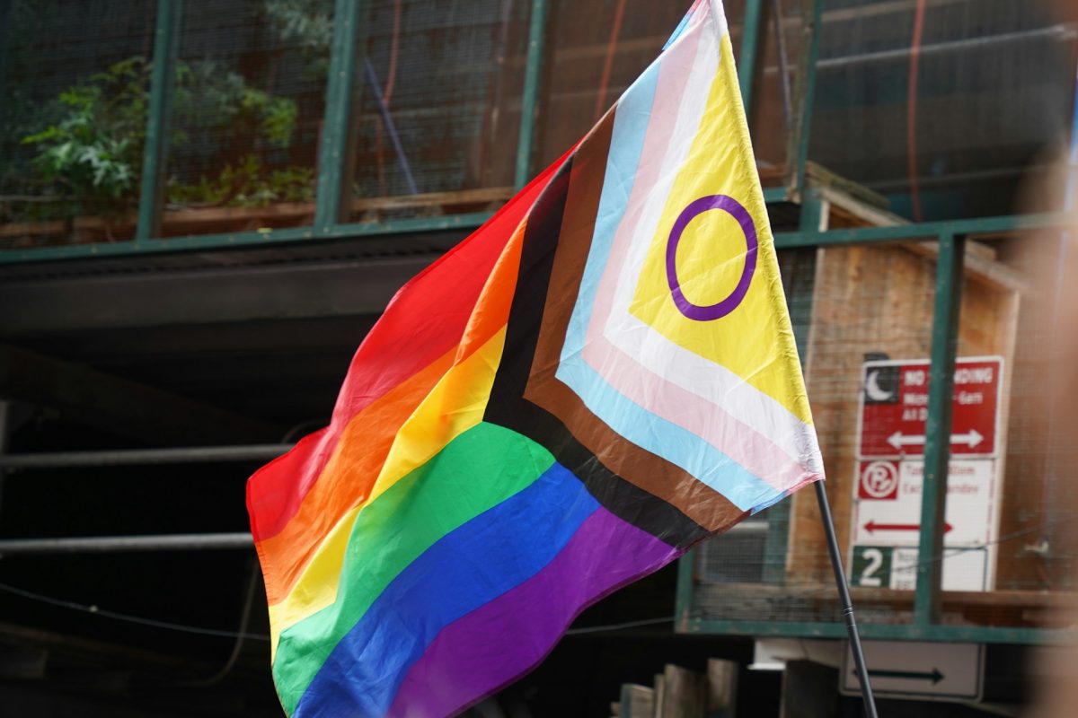 Progresívna dúhová vlajka hrdosti vlaje na verejnosti, symbolizujúca podporu rôznorodosti a inklúzie LGBTQ+ komunity.
