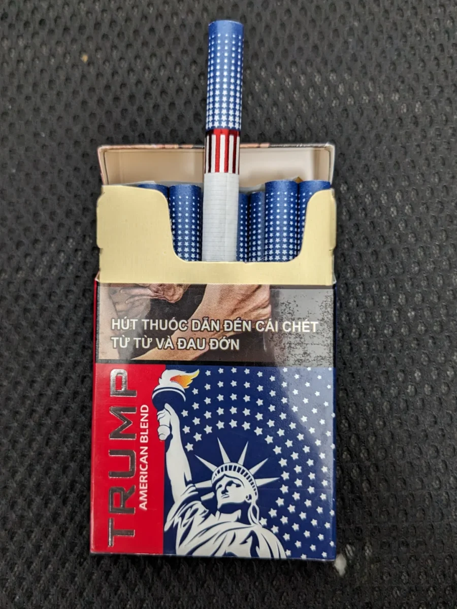 Otváraná škatuľka cigariet s modro-bielym dizajnom a motívom Sochy slobody.