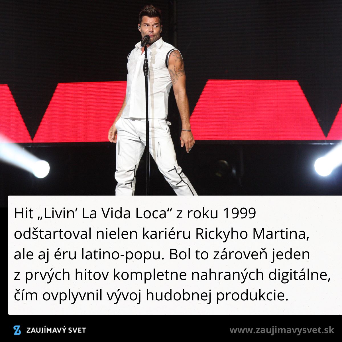 Spevák na pódiu s mikrofónom, efektné červené svetlá v pozadí pri energickom vystúpení.