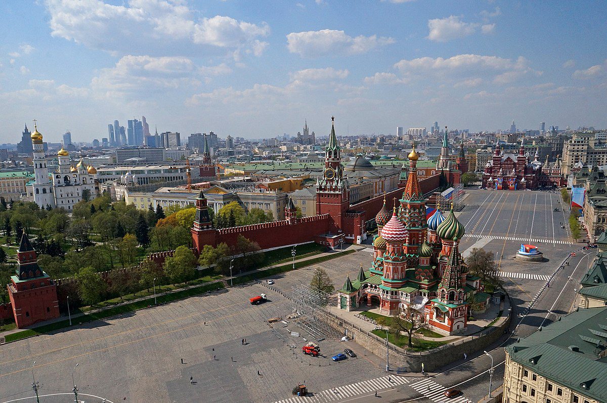 Pohľad na farebné kupoly v centre Moskvy s rozľahlým mestským panorámou v pozadí.