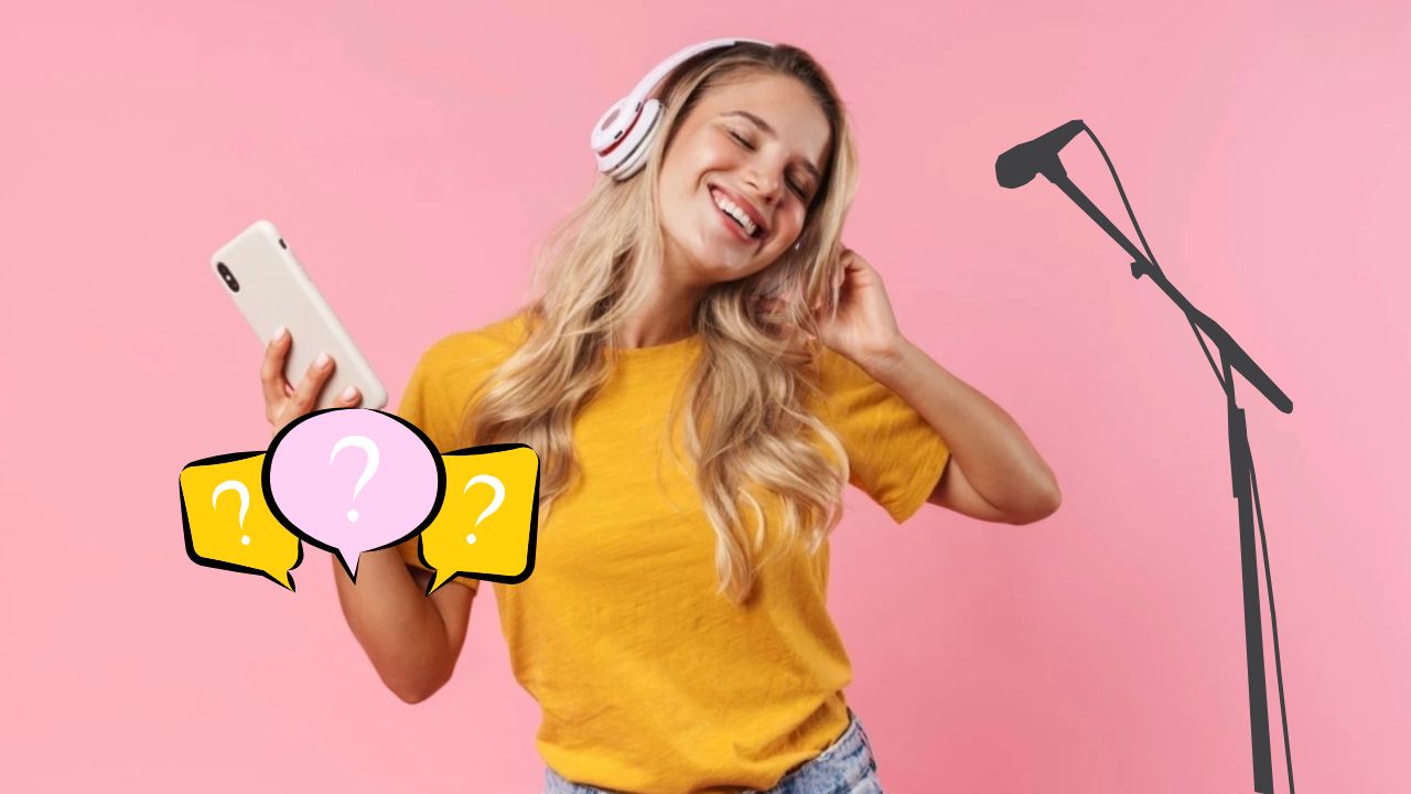 Žena v žltom tričku so slúchadlami a mobilom spieva pred mikrofónom na ružovom pozadí.