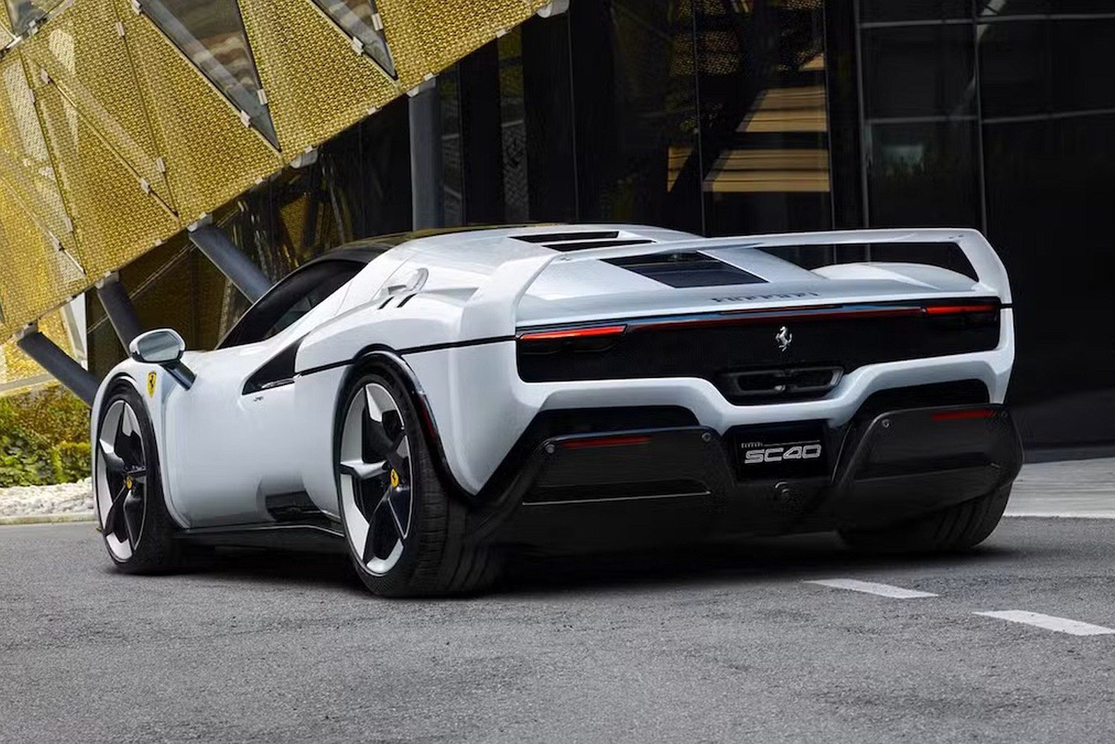 Luxusný biely športový automobil na parkovisku pred modernou architektúrou, pohľad zozadu.