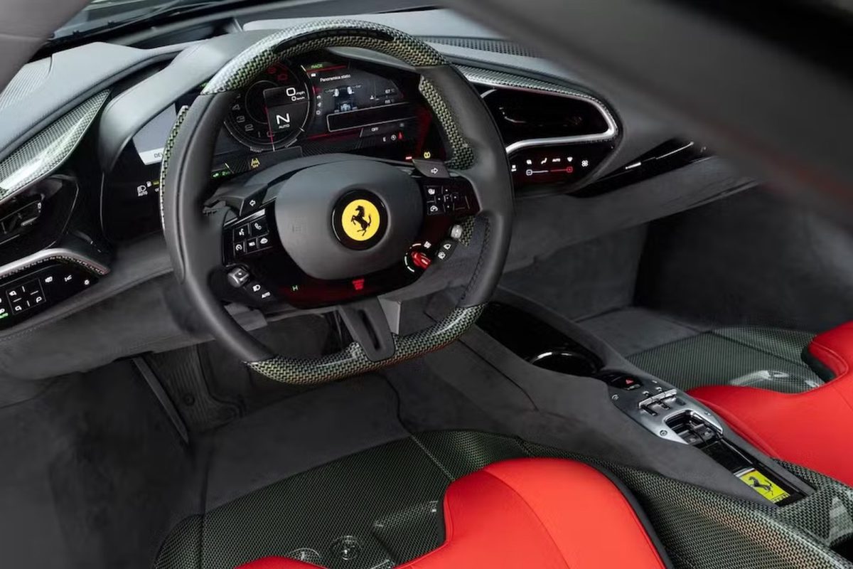 Interiér športového auta Ferrari s luxusným volantom a modernou prístrojovou doskou.