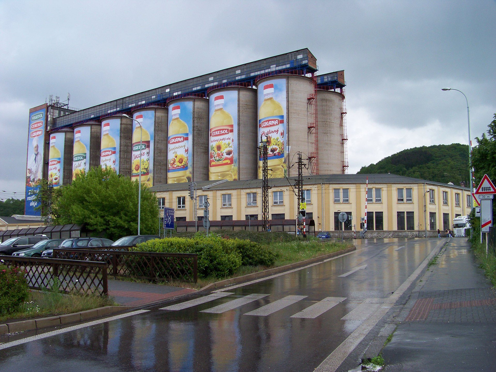 Priemyselná budova Setuza s veľkorozmernými reklamami na rastlinný olej v zamračenom počasí.