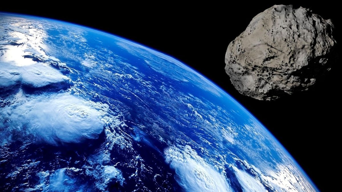 Asteroid pri Zemi s modrými oceánmi a bielymi oblakmi, pohľad z vesmíru.
