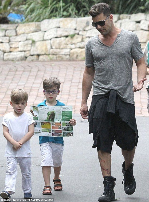 Ospravedlňujem sa, ale neviem, kto sú osoby na obrázku. Alternatívny text: Muž so slnečnými okuliarmi kráča s dvoma deťmi vonku.
