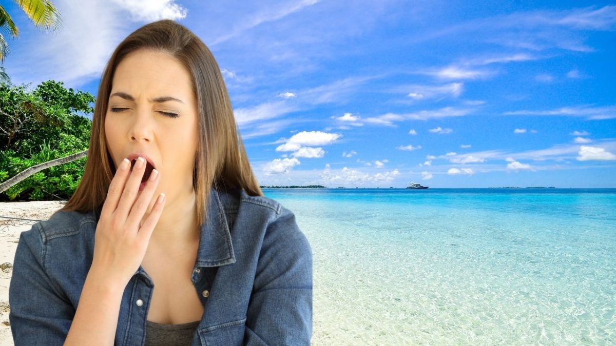 Žena zívajúca na slnečnej pláži s modrou oblohou a palmami v pozadí.