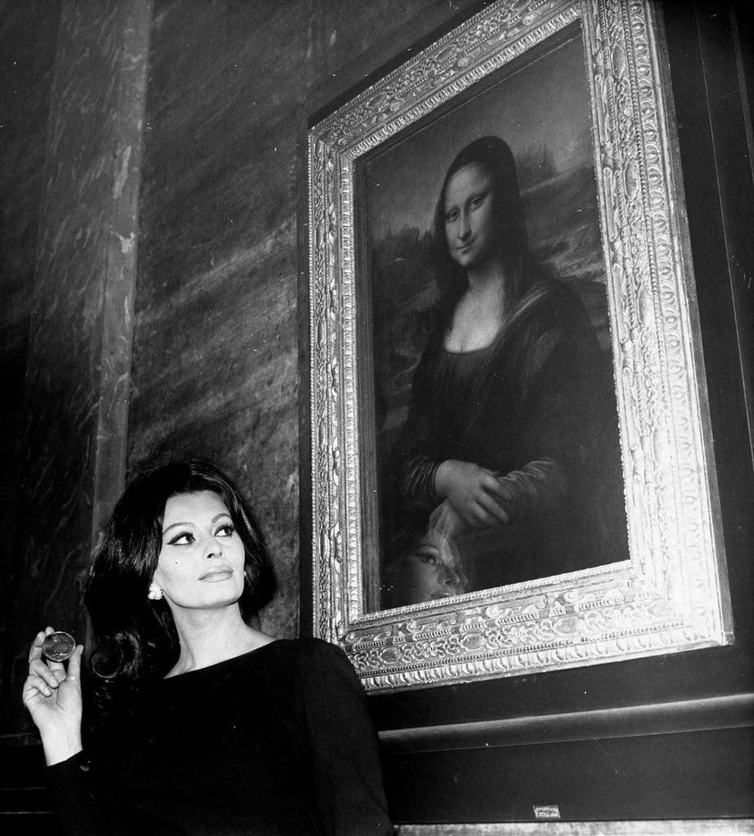 Osoba stojí vedľa známeho obrazu Mona Lisa v galérii, pozerá na obraz s údivom.