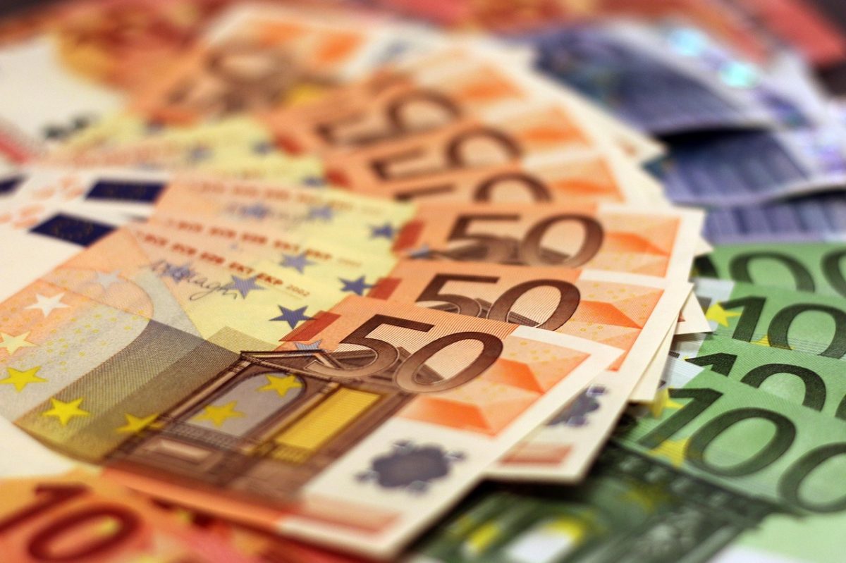Euro bankovky rôznych hodnôt položené na stole, zamerané na päťdesiatky.