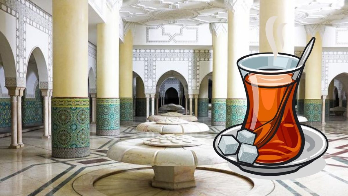 Tradičný čaj v sklenenej šálke na pozadí orientálnej architektúry s mozaikovými detailmi a oblúkmi.