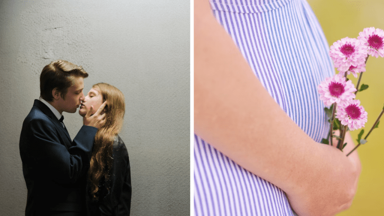 Ľudia si vymieňajú romantický bozk, žena drží ružové kvety pri elegantných pruhovaných šatách.