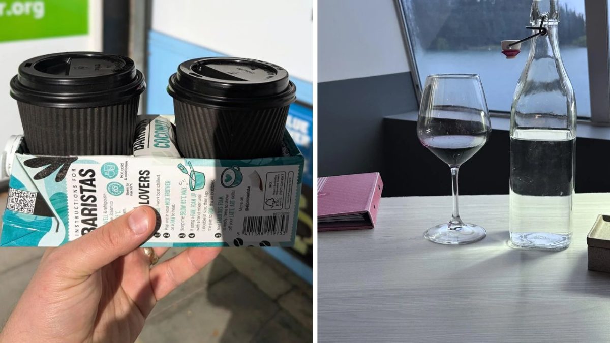 Dva čierne kávové poháriky v držiaku a pohár vína s fľašou vody na stole.