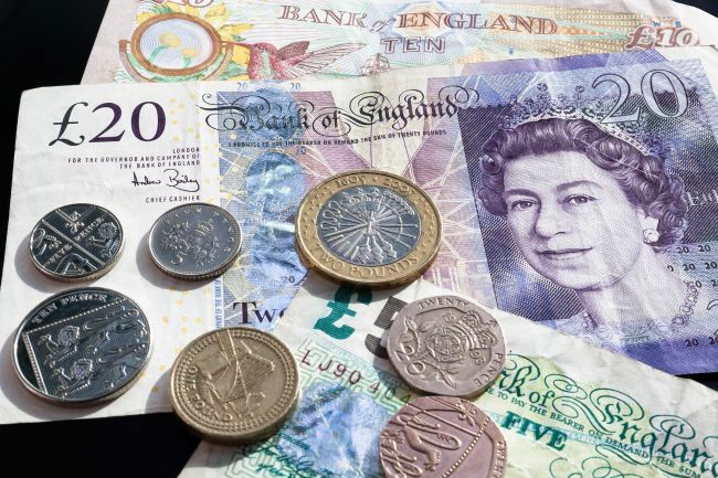 Britské bankovky a mince, vrátane £20 s portrétom, zobrazené vedľa seba ako symbol britskej meny.